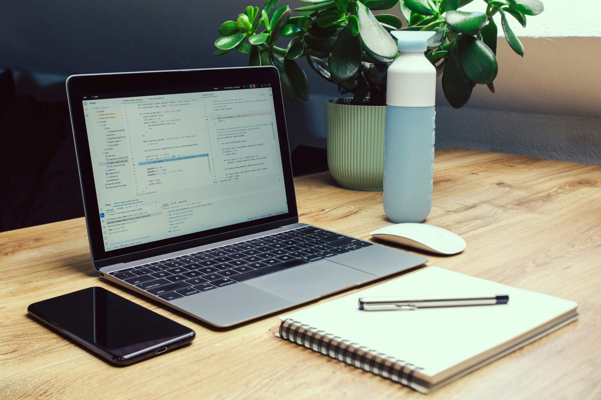 ein Notizblock, ein Stift, Obst und ein Ladegerät auf einem Tisch